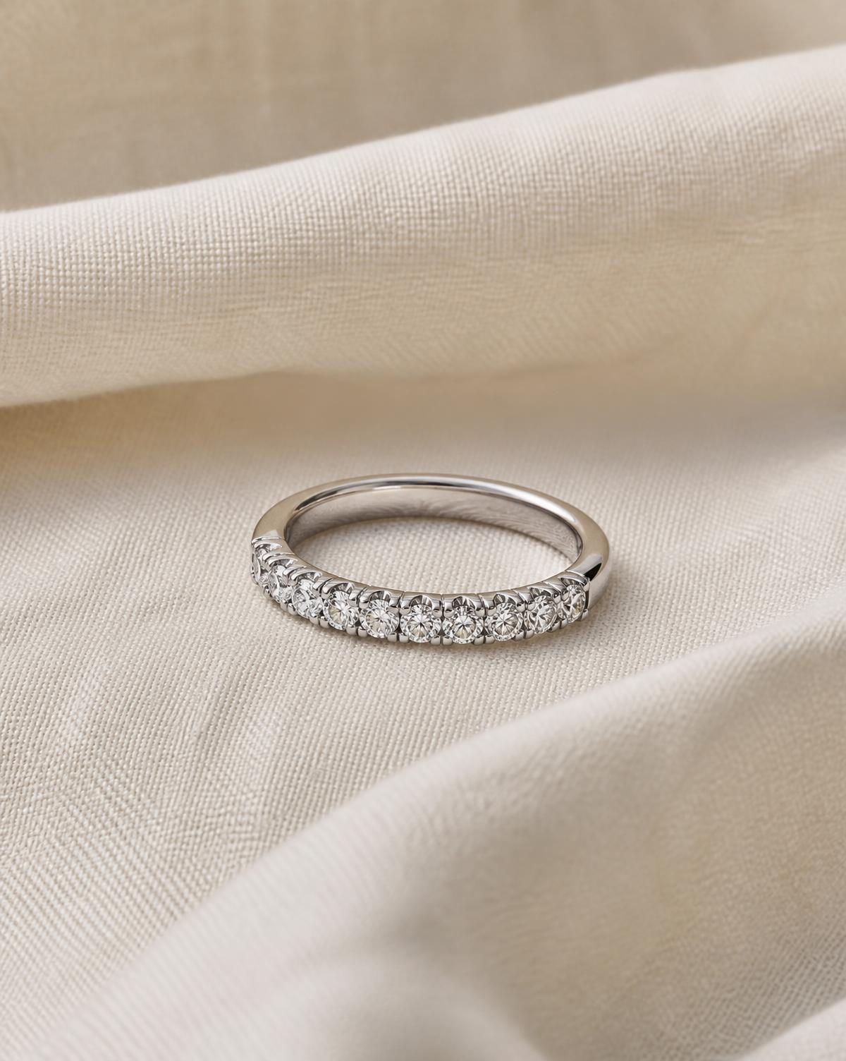 Half eternity band with small round moissanite stones on ivory linen