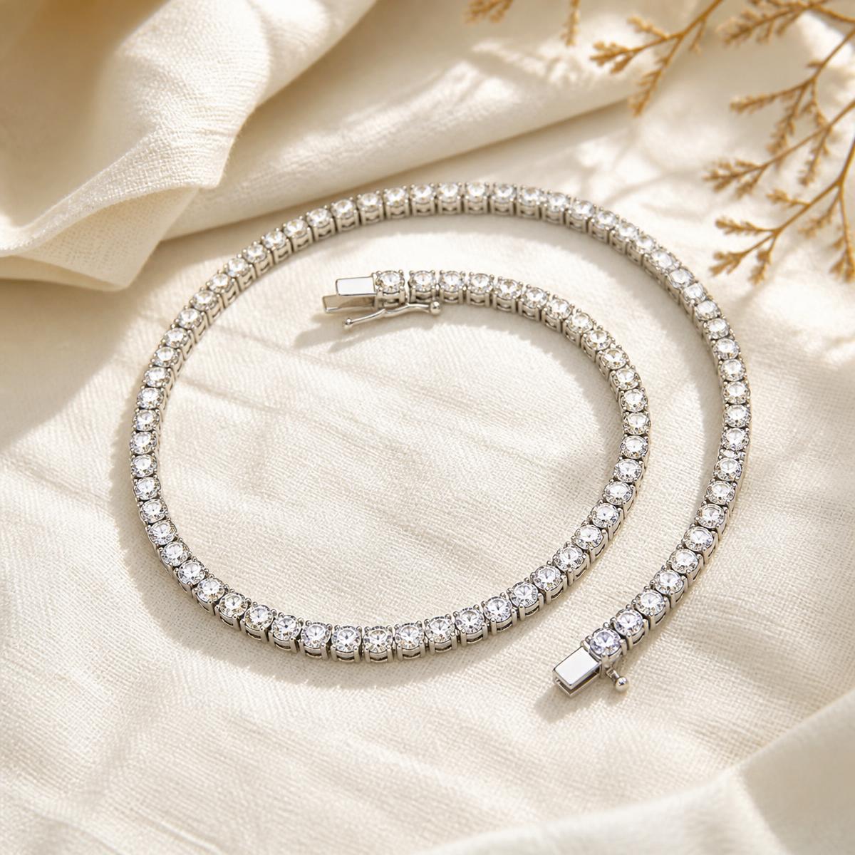Tennis moissanite necklace with a white-gold finish coiled on ivory linen